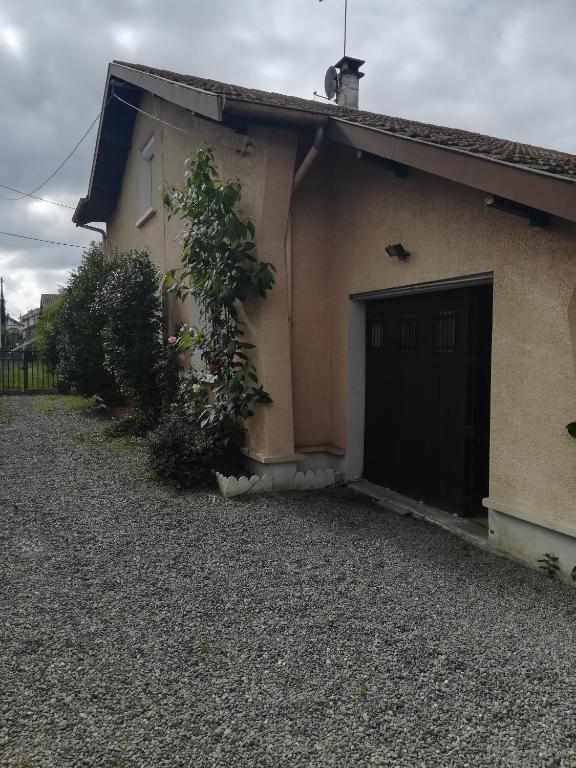 a building with a door and a tree next to it at La maison de J et B étage entier in Tarbes