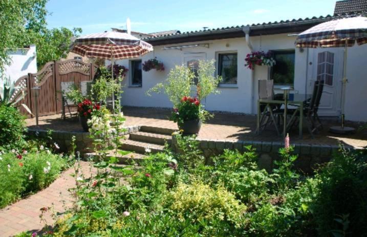 a garden with a house with a table and an umbrella at Ferienwohnung-Familie Beitz in Zirchow