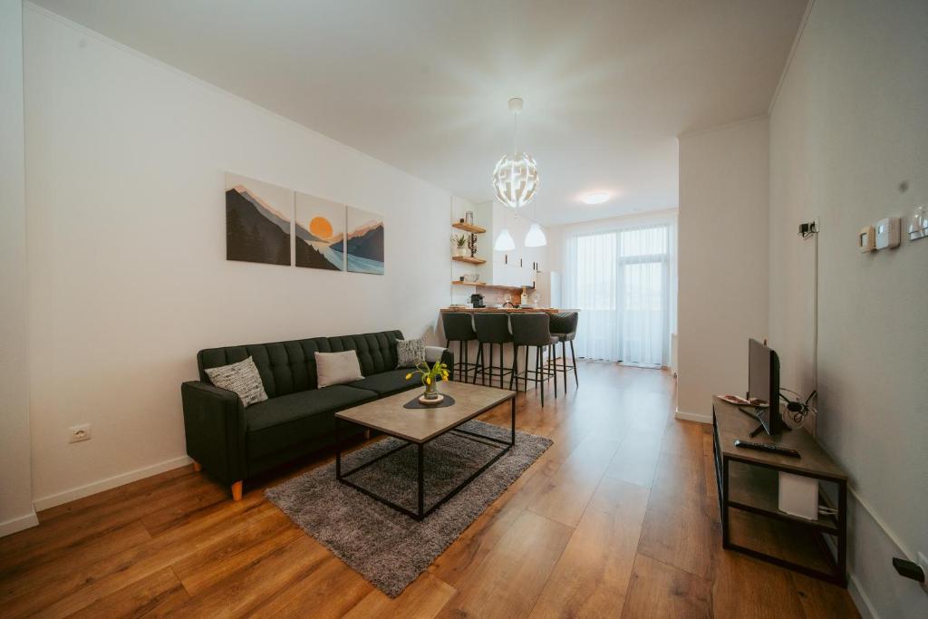 a living room with a couch and a table at Riverline Apartman in Odorheiu Secuiesc