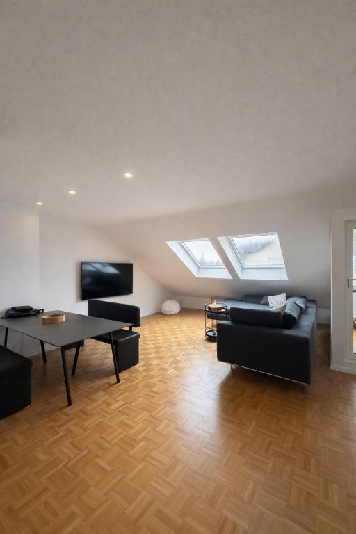 ein Wohnzimmer mit einem Tisch und einem Sofa in der Unterkunft Modernes Dachgeschossapartment in Singen Zentrum in Singen