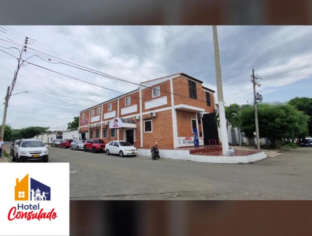 a building with cars parked in front of a street at HOTEL CONSULADO Junto al Consulado de Venezuela in Cúcuta