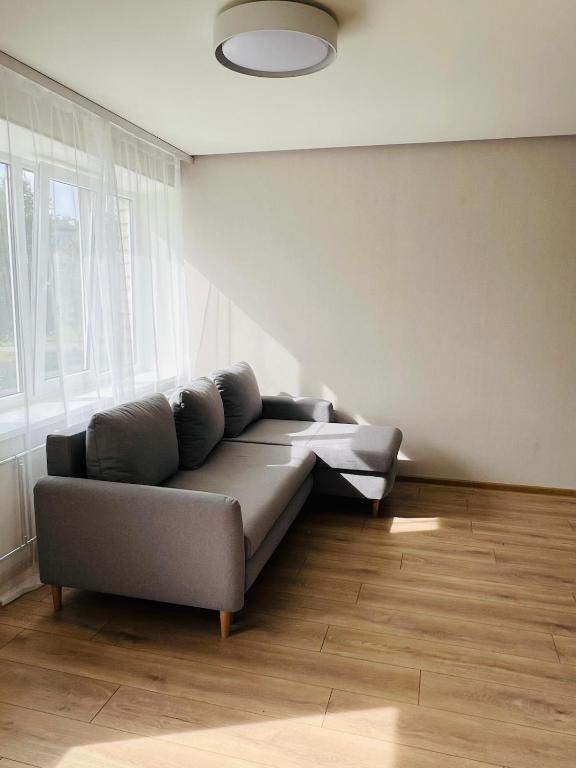 a living room with a couch and a window at White Sun Apartment in Aizkraukle