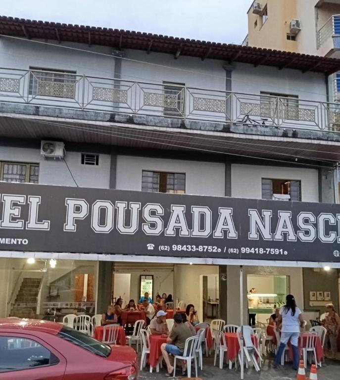 a sign for a restaurant in front of a building at Pousada Nascimento in Trindade