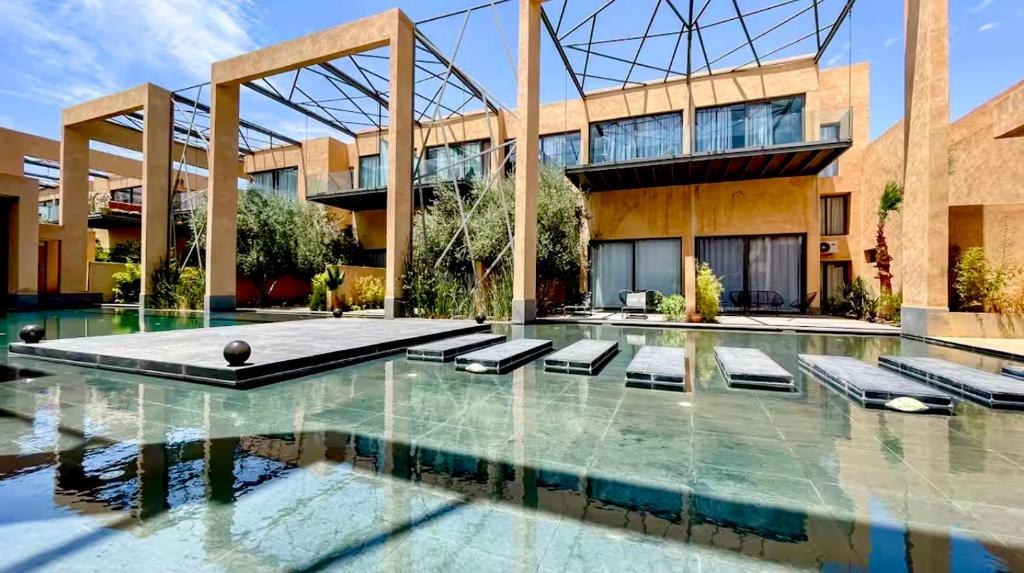 a swimming pool in front of a building at Cozy appartement Marrakech in Marrakesh