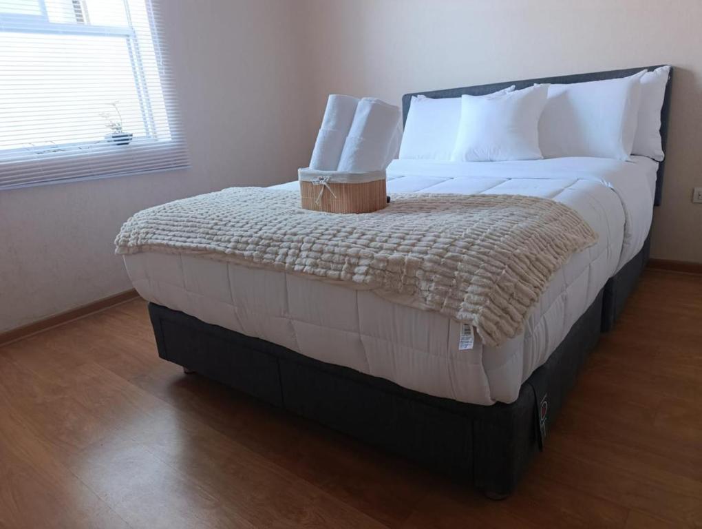 a large bed with white sheets and pillows in a room at The harmony suit in San Antonio