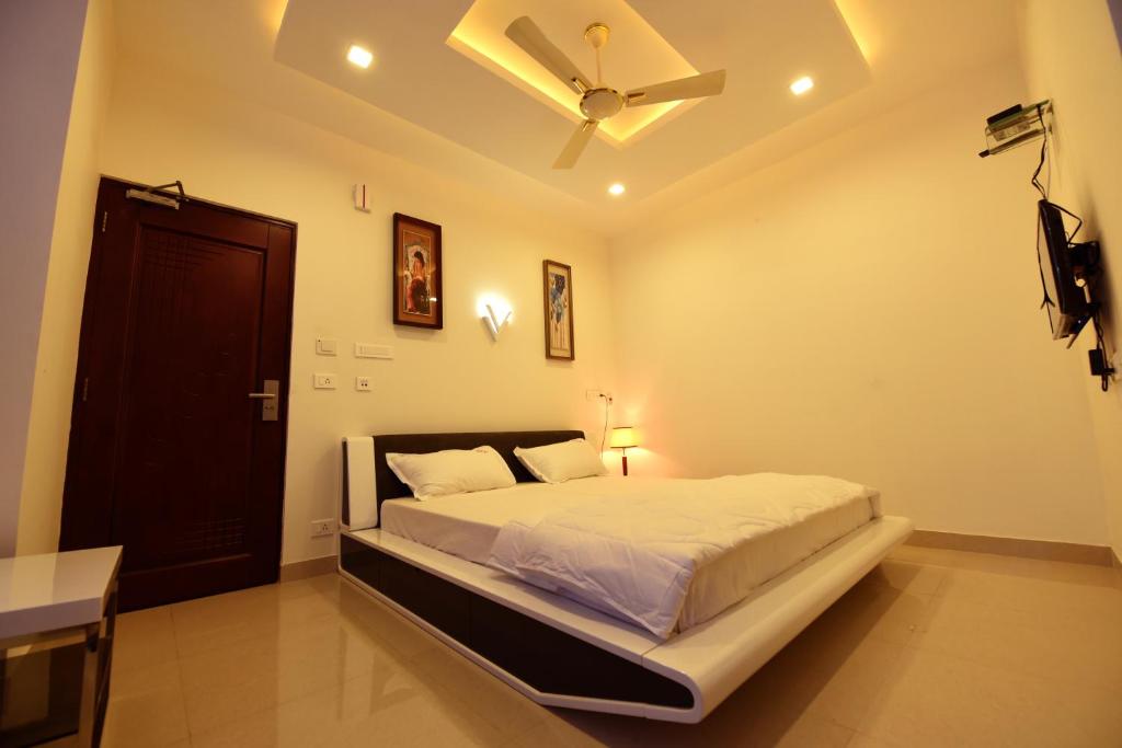 a bedroom with a bed with a ceiling fan at Sky Residency in Chennai