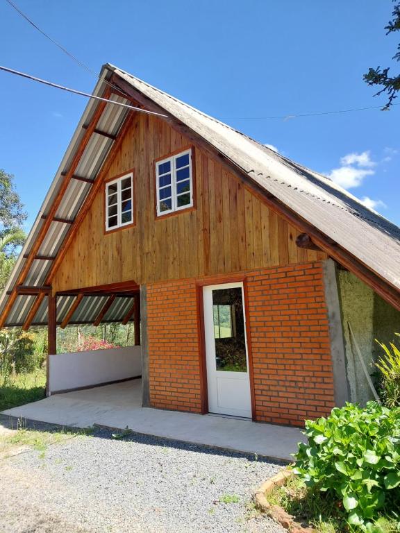 a red brick house with a white door at Chale Primavera in Benedito Novo