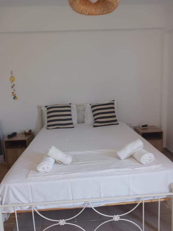 a large white bed with two pillows on it at Andros Summer House II in Andros