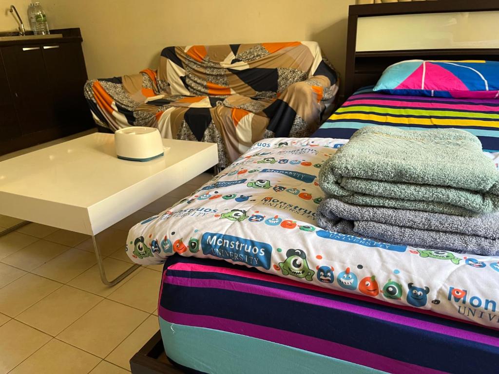 a bedroom with a bed and a table with towels at Impact Arena C9 by Jintana in Thung Si Kan