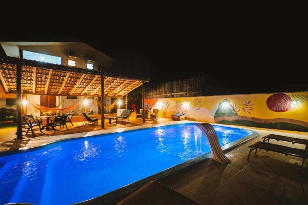 a large swimming pool at night with a pool at Pousada das Estrelas in Itaúnas