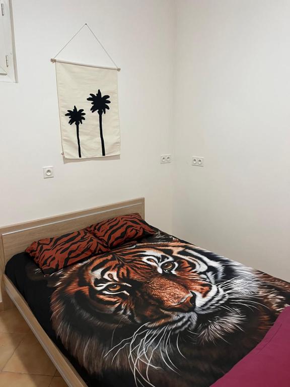 a bed with a painting of a tiger and palm trees at Studio Centre Ville in Tarbes