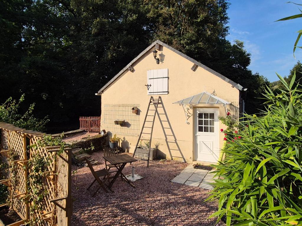 a small building with a ladder next to a door at Le Moulin de serres in Bazoches
