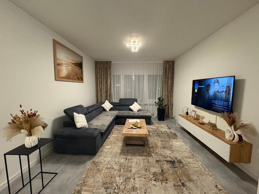 a living room with a couch and a tv at Glory's Apartment in Dußlingen