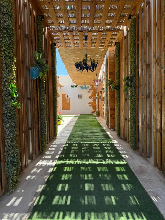 a hallway with green flooring and a wooden ceiling at Le charbon élégant in Bin Rhilouf