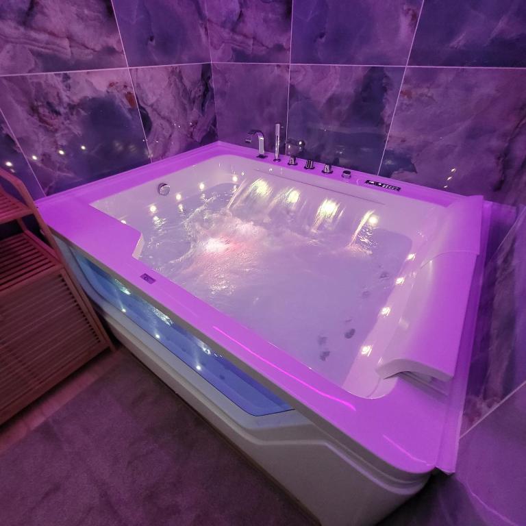 a purple bathroom with a tub in a room at TOP1 Templum Luxuriae in Reggio di Calabria