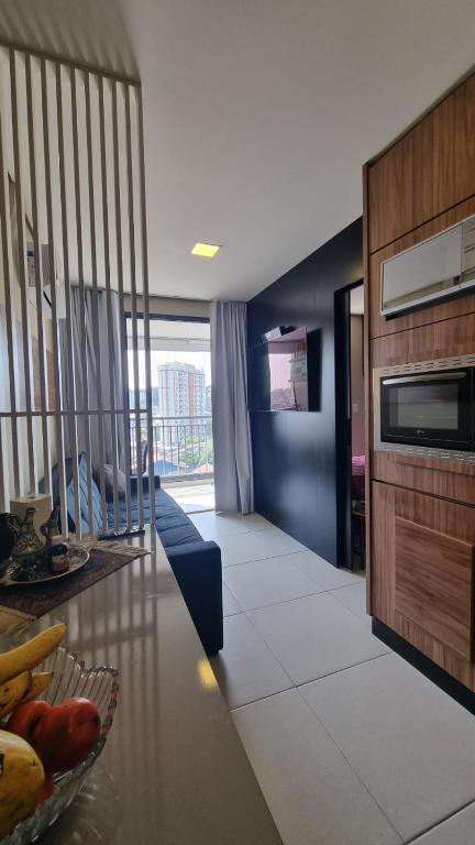 a kitchen and living room with a bowl of fruit on a table at Studio Comfort apartament Arujá in Arujá