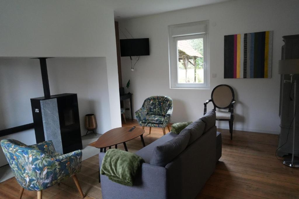 a living room with a couch and chairs and a window at Chez Rachel in Mérélessart