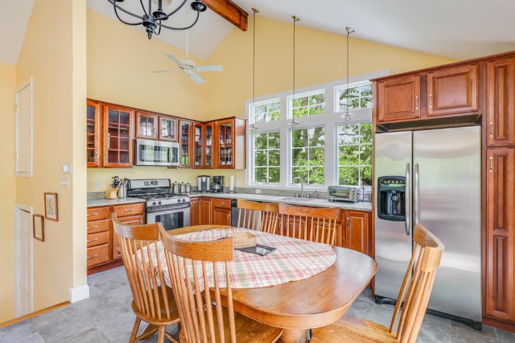 a kitchen with a wooden table and a refrigerator at Pleasant Point in Wellfleet