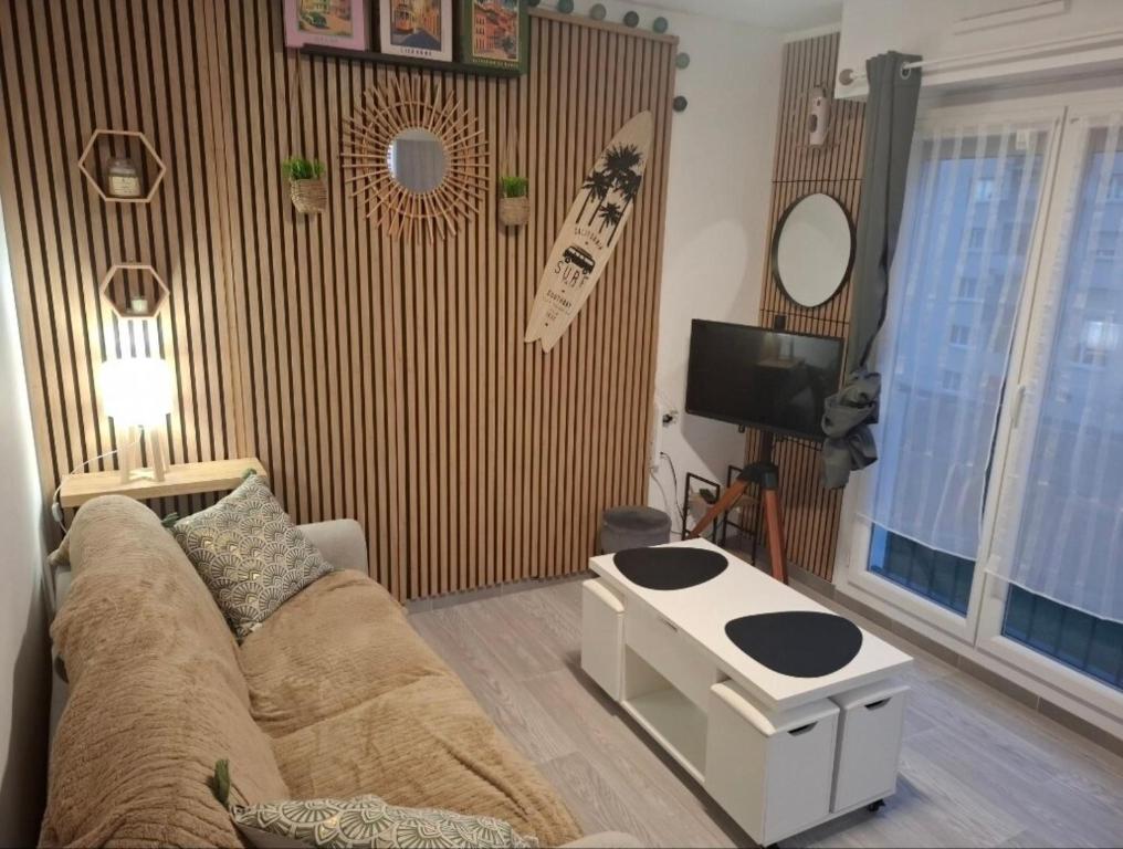 a living room with a couch and a table at Charmant studio Thionville in Thionville