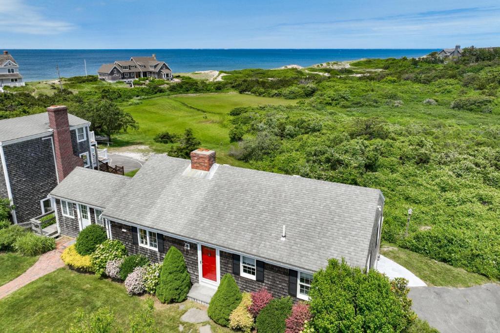 an aerial view of a house with the ocean in the background at Le Petit Château in Dennis