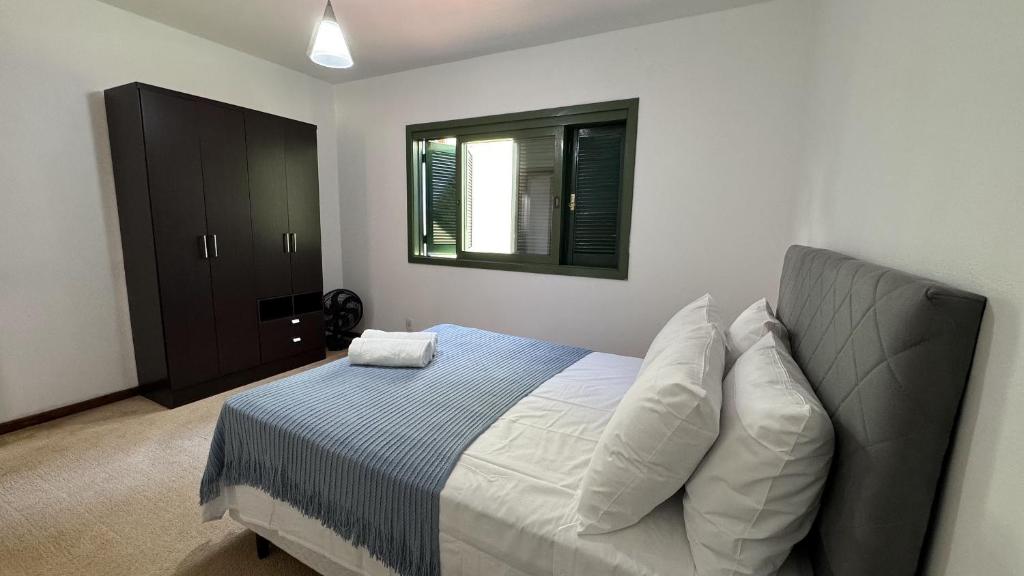 a bedroom with a bed and a window at Apto 2D ensolarado, sacada e garagem, centro in Nova Petrópolis