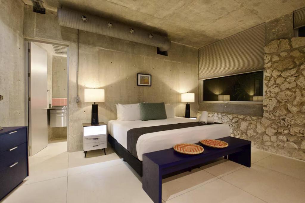 a bedroom with a bed and a table in it at Casa Piedra Villa in Cancún