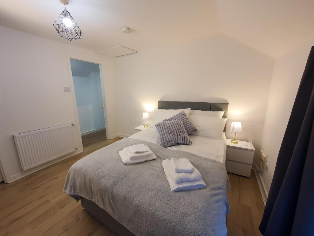a bedroom with a large bed with towels on it at FLAT 2 Seven Cambrian Square First Floor Flat in Newtown