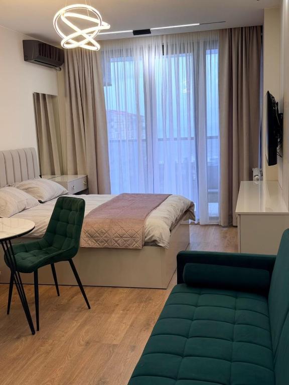a bedroom with a bed and a table and a couch at next apartment lux in Batumi