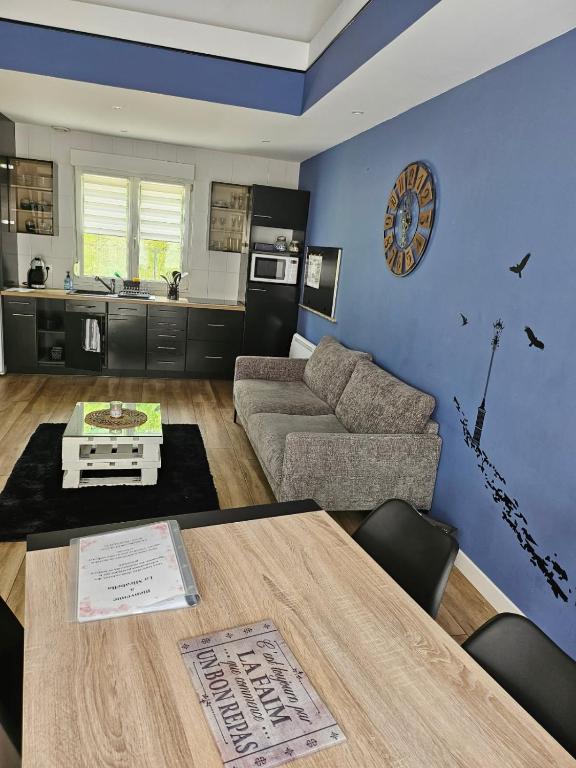 a living room with a table and a couch at Arboréa, charmant loft in Mirebeau-sur-Bèze