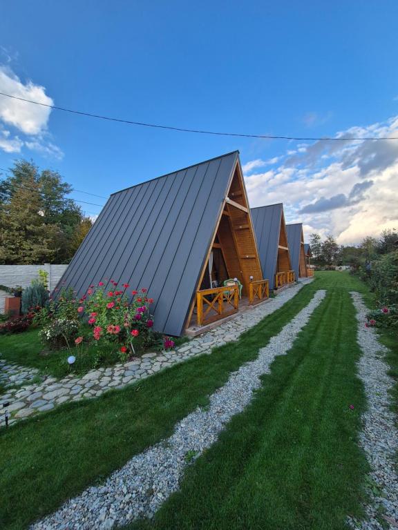 a house with a metal roof and a yard at Cabanele Avoca in Avrig