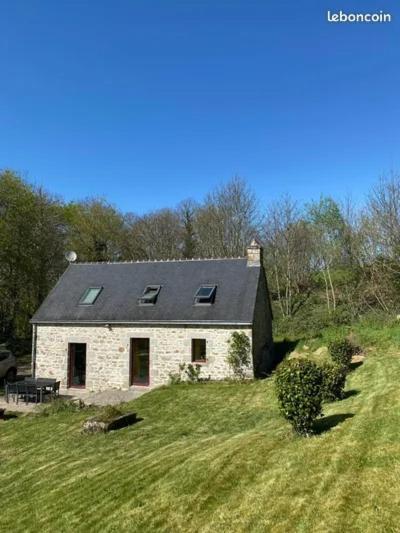 a stone house on top of a grassy hill at Charmant penty pour un séjour calme et reposant in Ergué-Gabéric