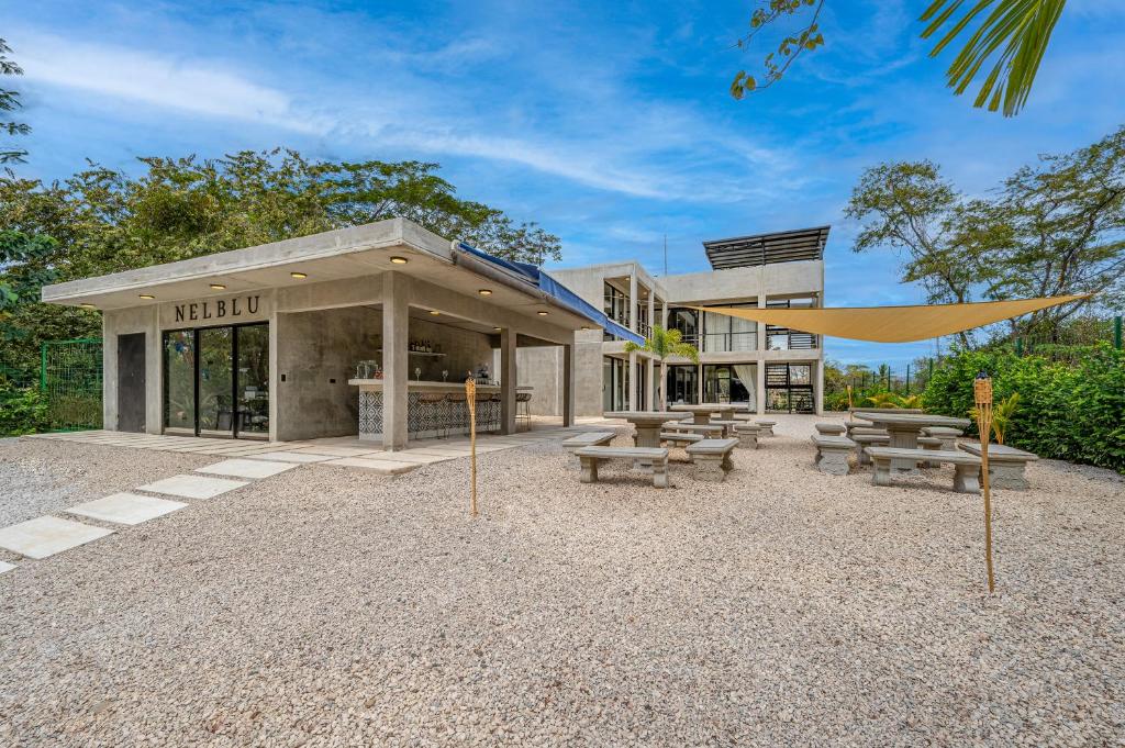 a building with picnic tables and benches in front of it at Nelblu Flamingo Suites in Playa Flamingo