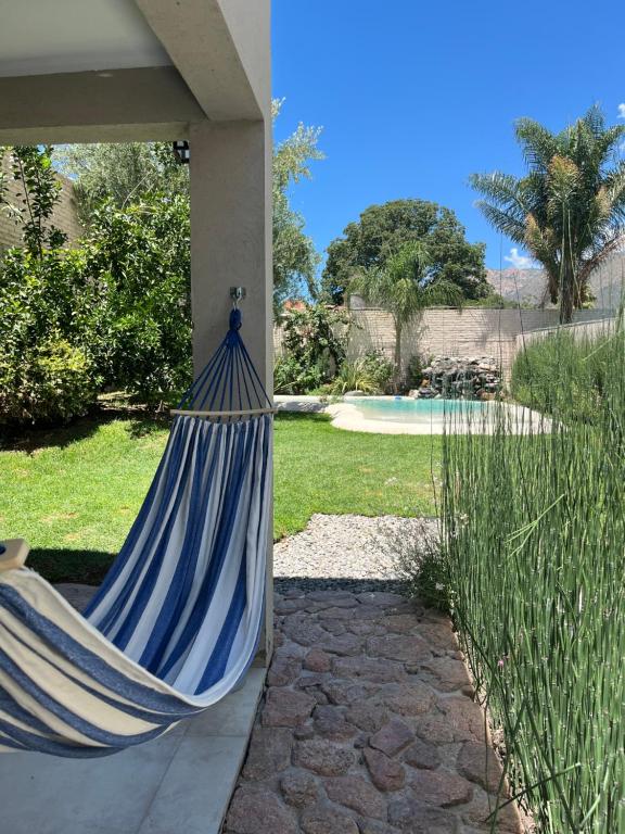 a blue hammock hanging from a porch with a yard at H Molle in Cafayate