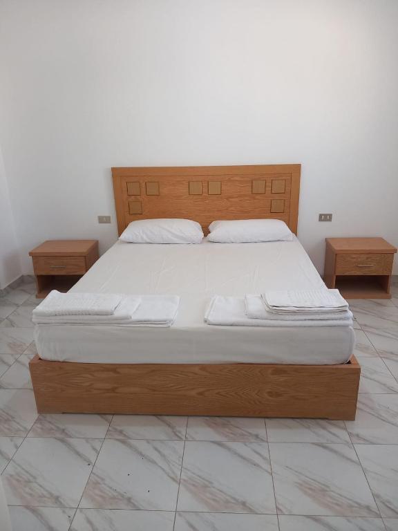 a bed with a wooden frame and two nightstandumentsomaly at Sea simple haven in Sharm El Sheikh