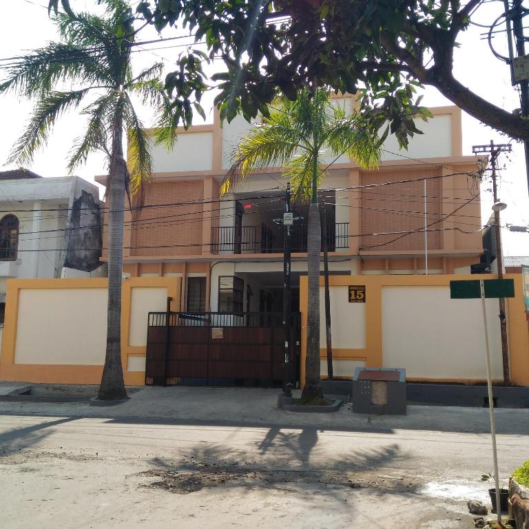 a building with two palm trees in front of it at K15 Exclusive in Malang
