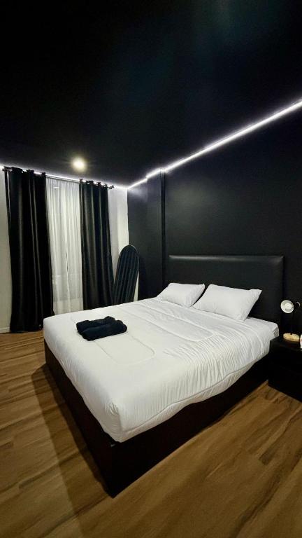 a bedroom with a large white bed with lights on it at Atrium Kathu Hotel in Ban Kathu (1)