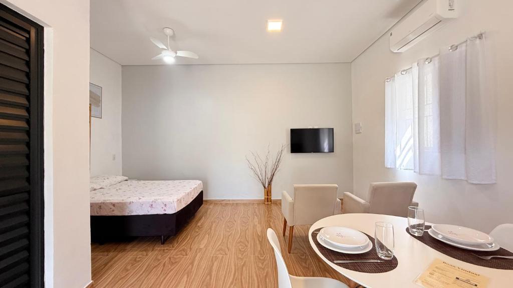 a white room with a bed and a table and chairs at Studio 209-AP2 espaço completo ideal para casal in Ubatuba