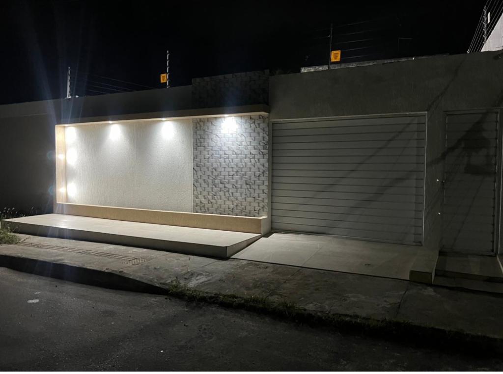 a building with a garage door on a street at night at Cada da lanny in Camaçari