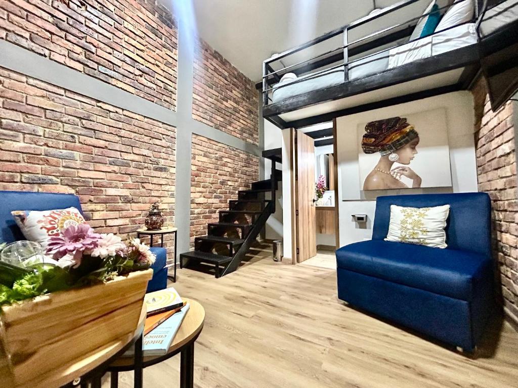 a living room with a blue couch and a brick wall at Tu Hotel Chía in Chía