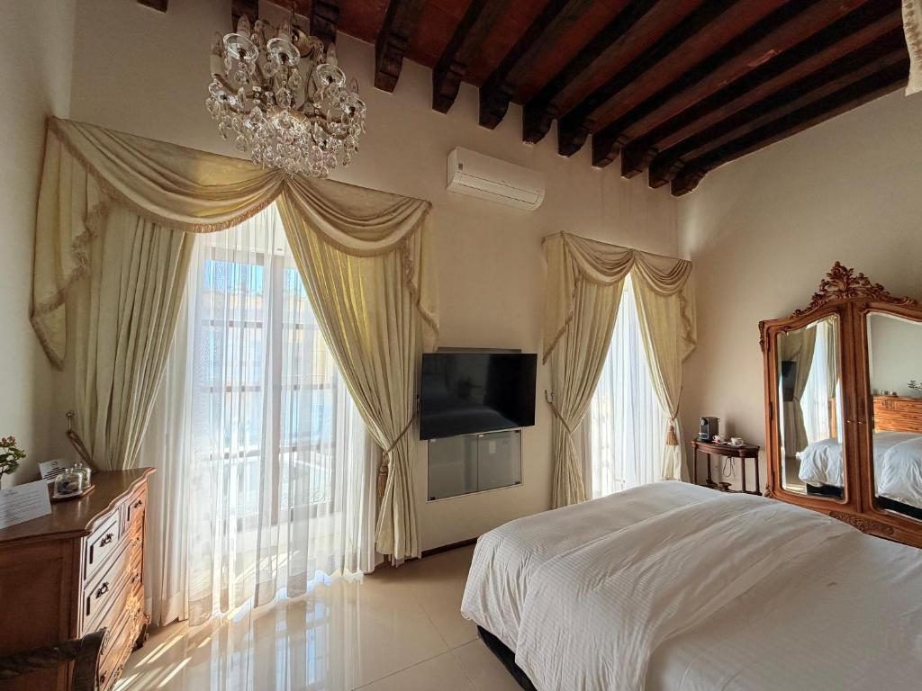 a bedroom with a bed and a chandelier at Ébano Hotel Boutique in Oaxaca City