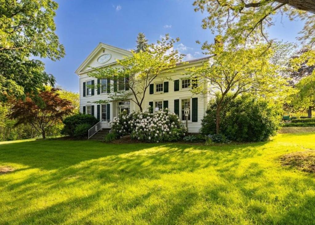 a white house with a large yard at Oak & Anchor Inn in Penn Yan
