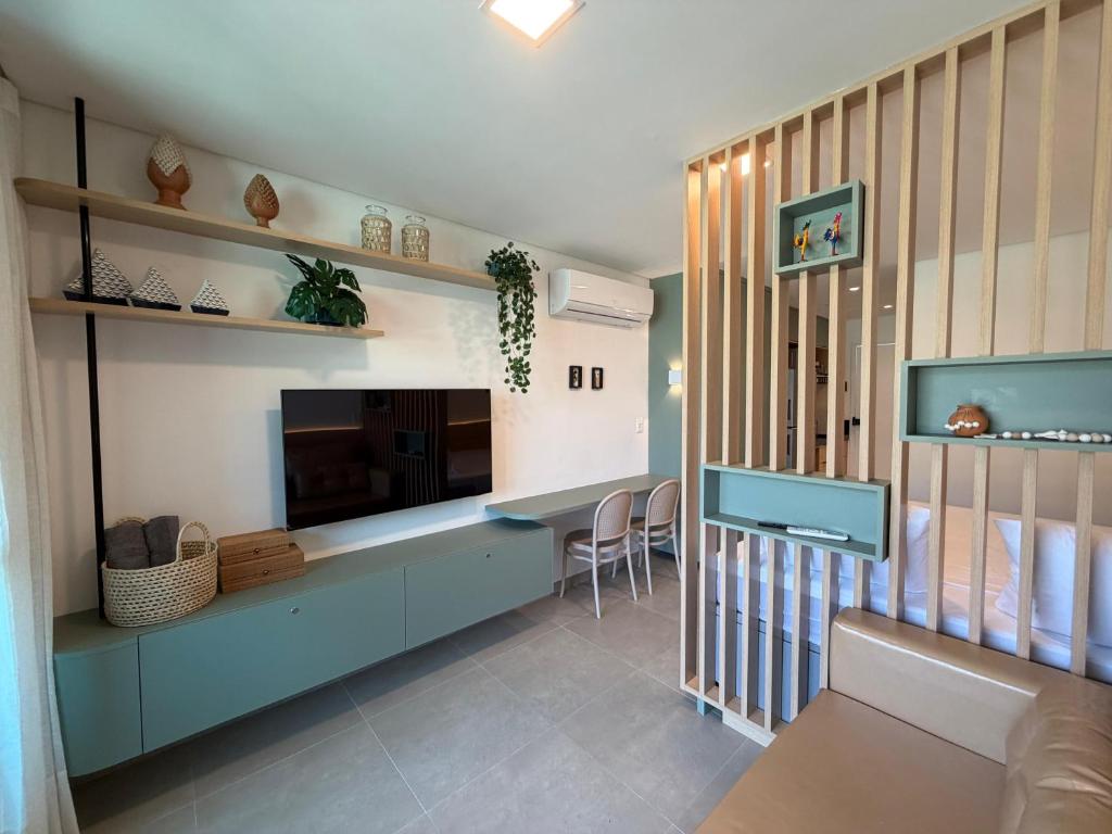 a living room with a tv and a blue cabinet at Flat Premium Muro Alto-conforto a 150m do mar in Ipojuca