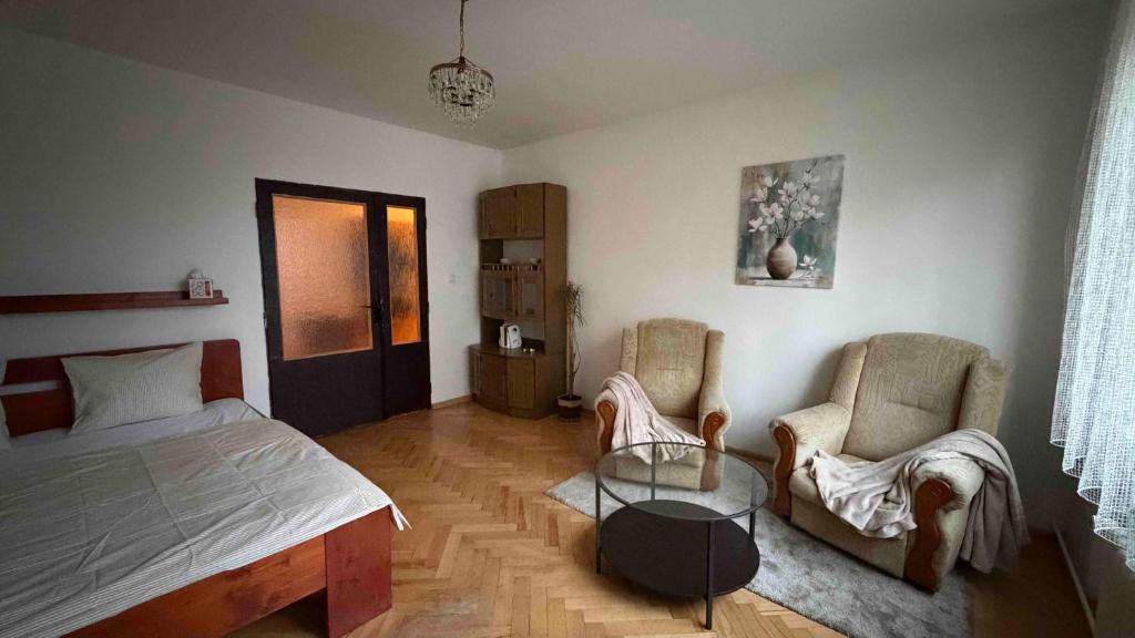 a bedroom with a bed and two chairs and a table at U Aleny pod Radhoštěm in Rožnov pod Radhoštěm