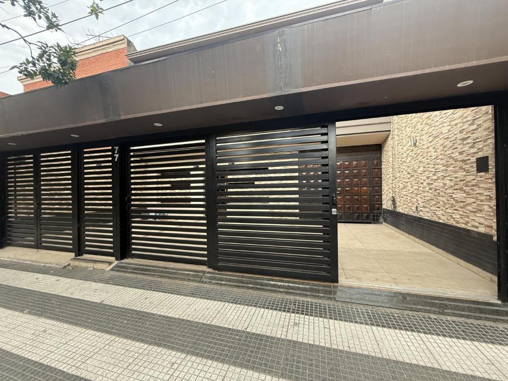 a building with two garage doors and a sidewalk at Hotel Haití in San Miguel de Tucumán