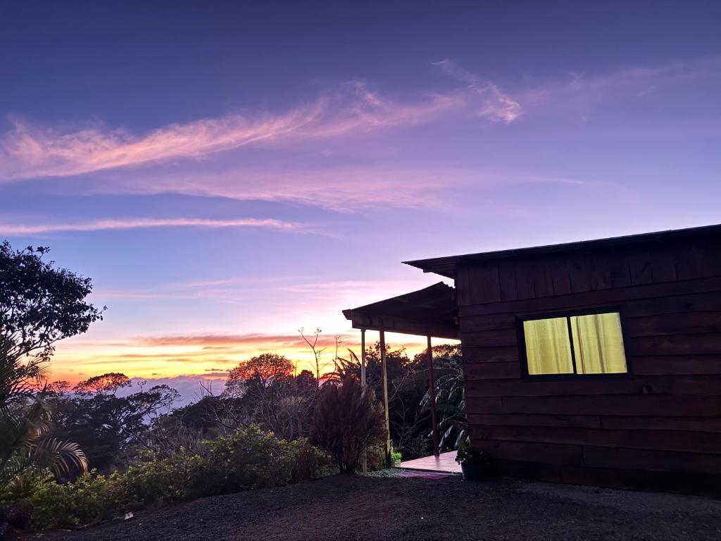 a cabin with a view of the mountains at sunset at Magic Lodge - Cirrí, Naranjo in Cirrí