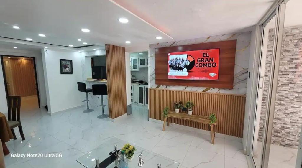 a living room with a television on a wall at Obynb in Santo Domingo