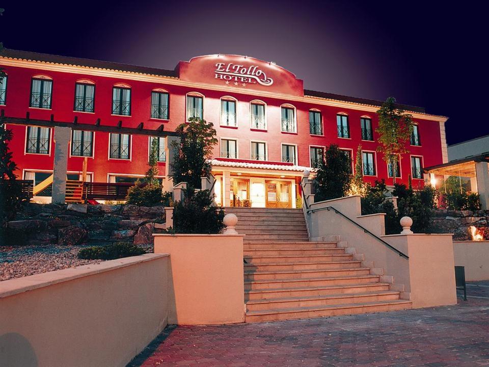 a large red building with stairs in front of it at Hotel Restaurante El Tollo in Utiel