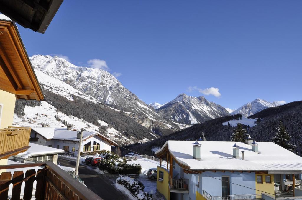a view from the balcony of a resort with snow covered mountains at P&P Home in Valdidentro