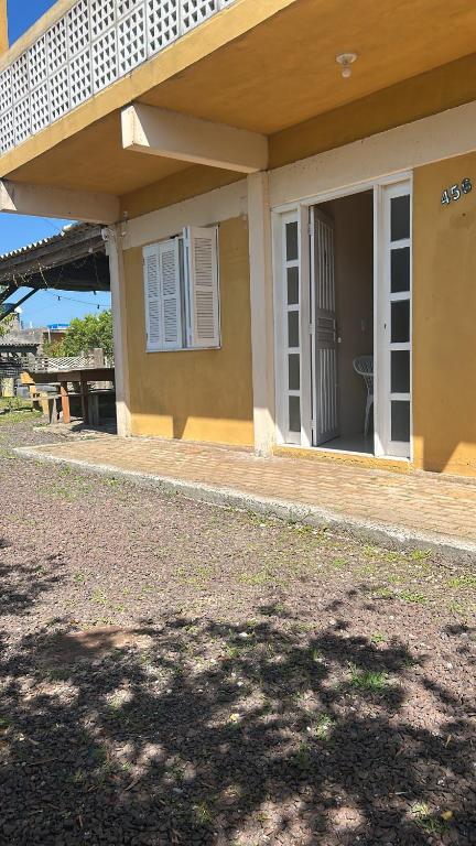 a house with a porch with a door open at Pousada Mar & Sol in Torres