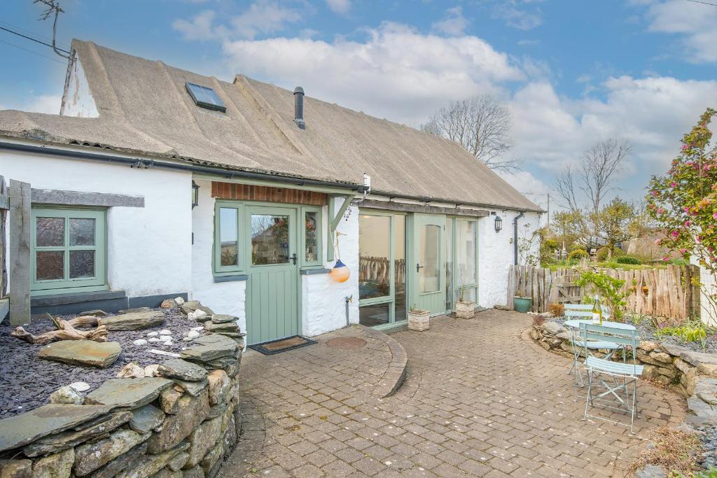 a white house with a stone wall and a patio at Y Sied in Newport